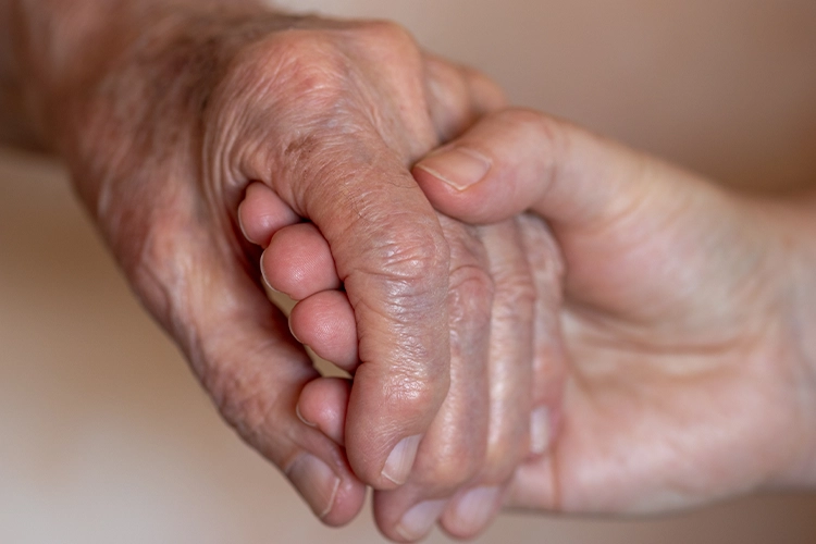 Hand einer jungen Person hält Hand einer alten Person