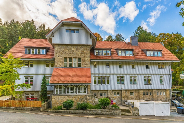 Großes Gebäude mit Natursteinfassade und grauer Holzverkleidung