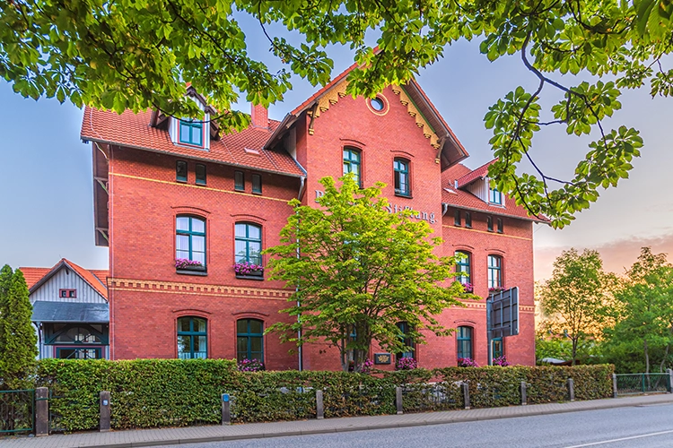 Historisches Backsteingebäude mit Bäumen im Vordergrund