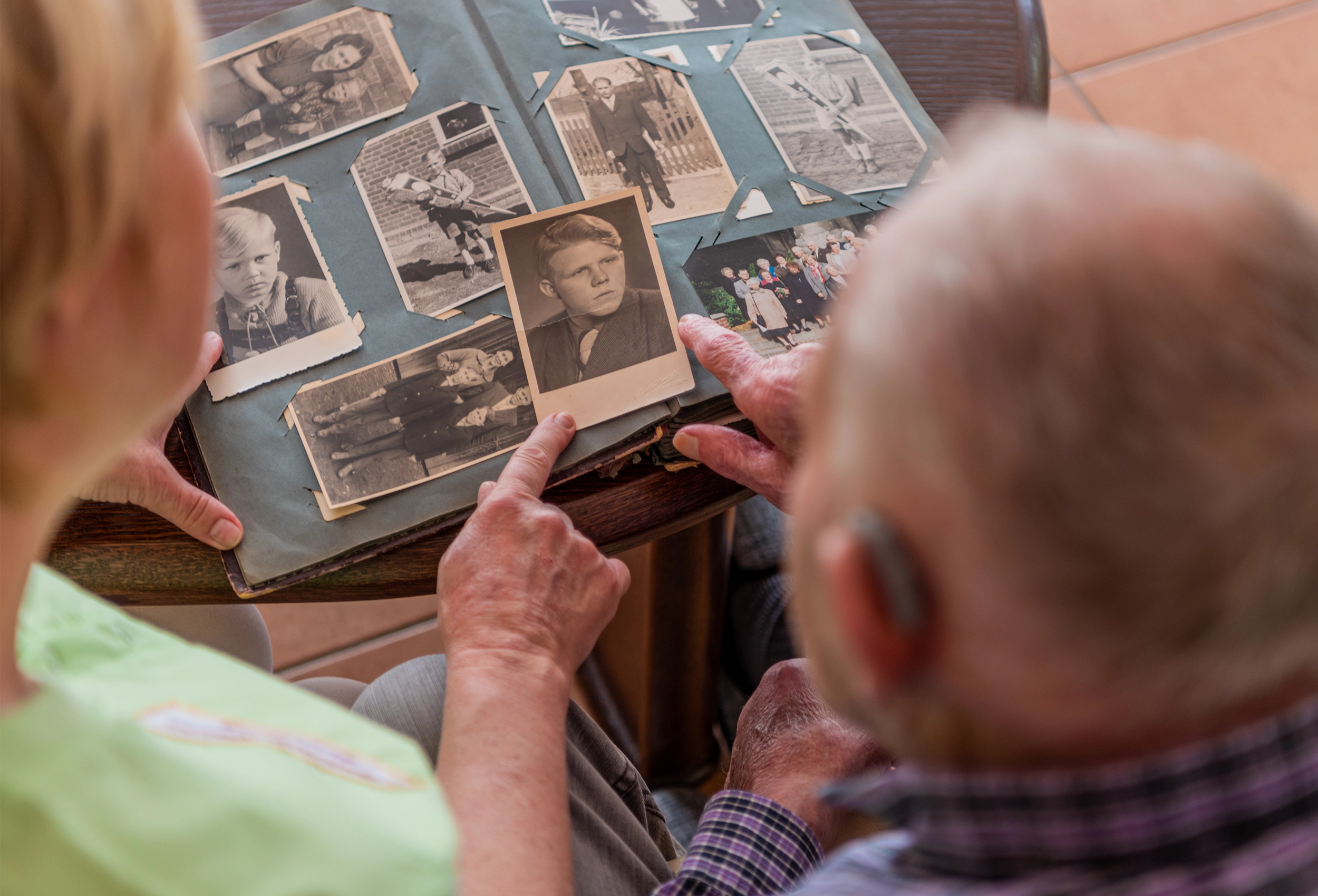 zwei Personen schauen gemeinsam ein Fotoalbum an