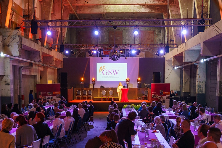 Festveranstaltung mit Bühne und Publikum in Industriehalle