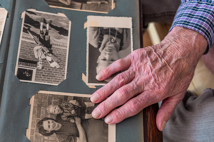 Ältere Hand blättert durch ein Fotoalbum
