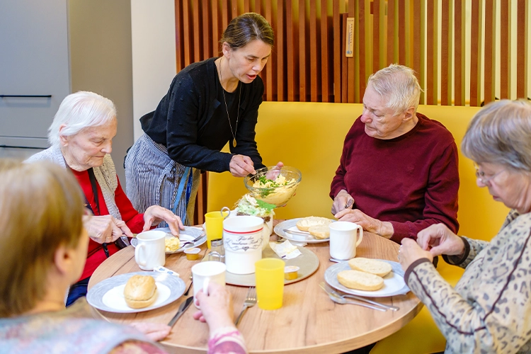 Gemeinsames Essen von Senioren mit Betreuungsperson