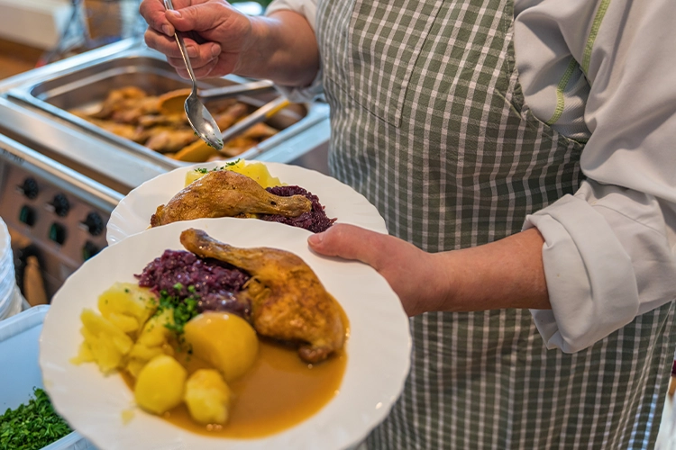 Serviertes Mittagessen mit Hähnchen, Kartoffeln und Rotkohl