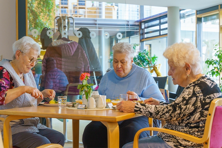 Drei Seniorinnen essen zusammen am Tisch