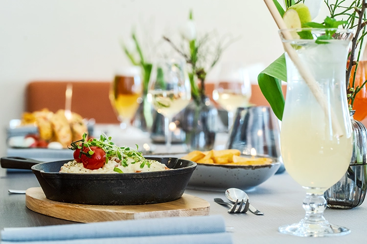 Restauranttisch mit Getränk und frisch zubereitetem Gericht