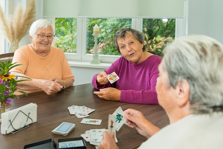 Seniorinnen spielen Karten am Tisch