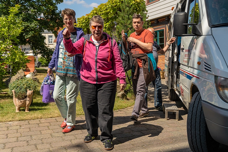 Menschen steigen aus einem Transporter aus