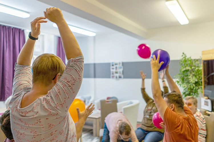 Gruppe spielt mit Luftballons im Raum