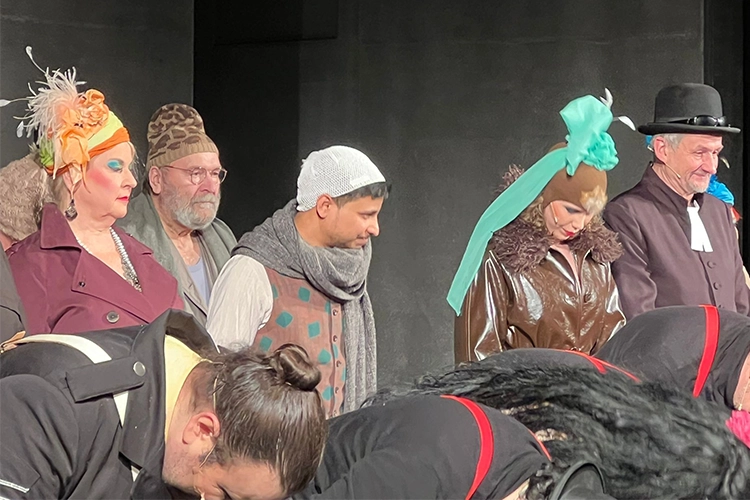 Darsteller stehen nach einer Theateraufführung gemeinsam auf der Bühne und verbeugen sich