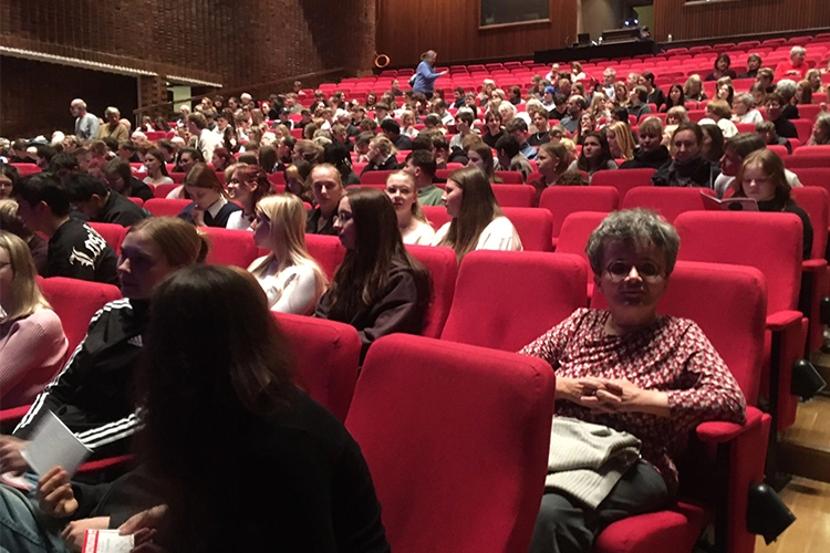 Besucher sitzen vor Beginn einer Veranstaltung im Theatersaal